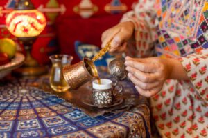 Pouring turkish coffee from cezve into cup
